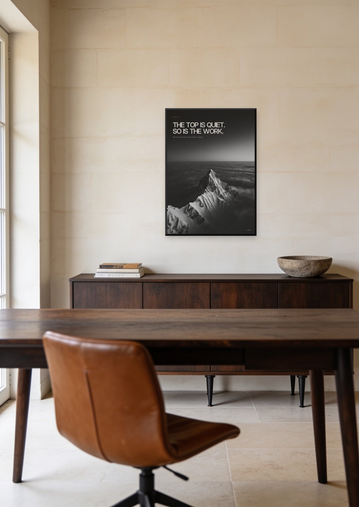 The Top Is Quiet, framed in black, above a walnut credenza in a limestone office