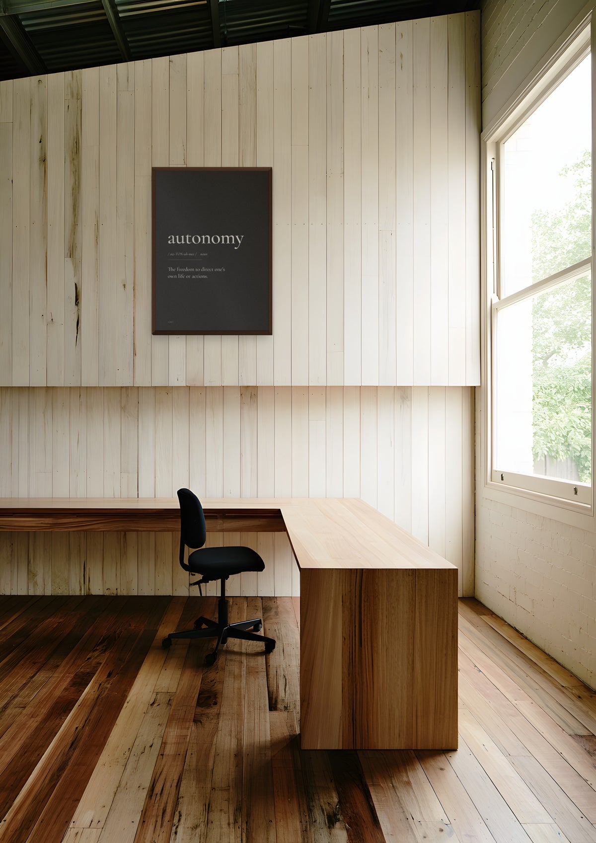 Autonomy (Black) in a dark wood frame, shown in melbourne-warehouse-office