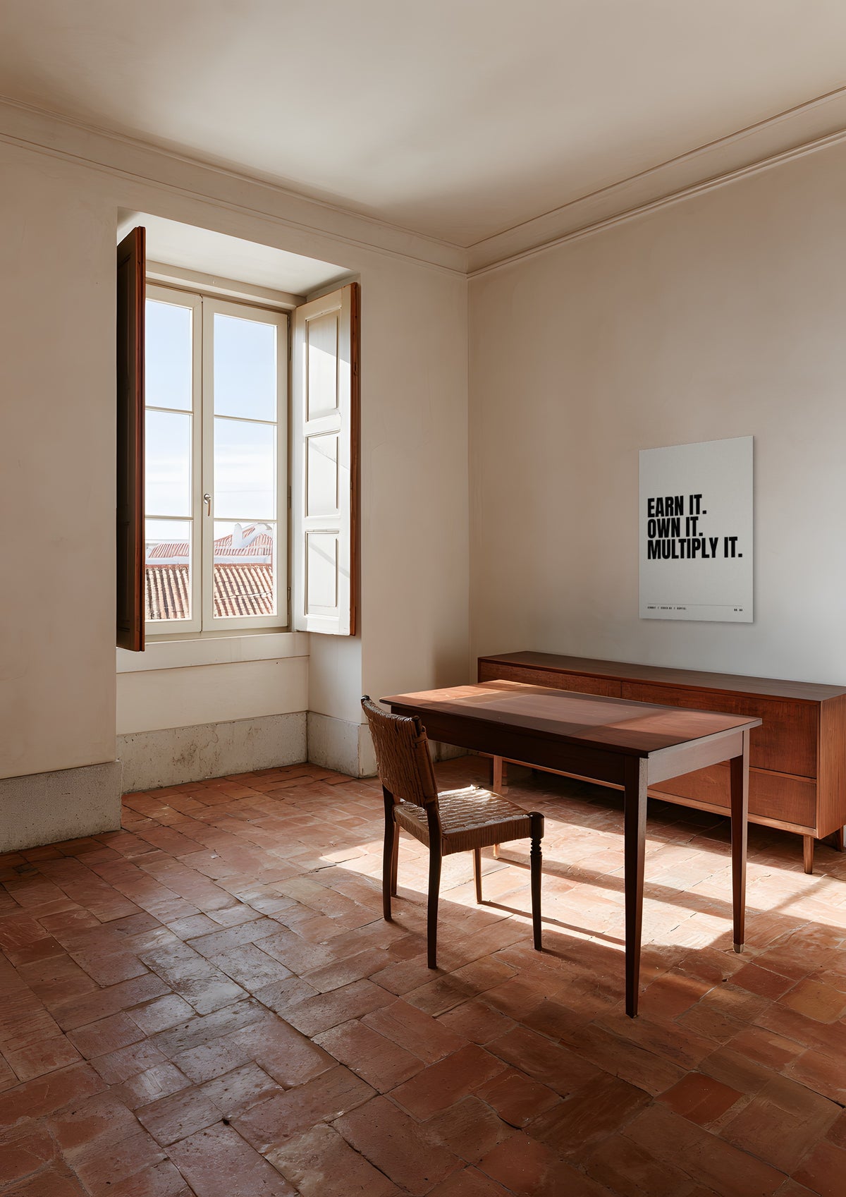 Earn It. Own It. Multiply It., unframed art print shown in a Lisbon apartment study