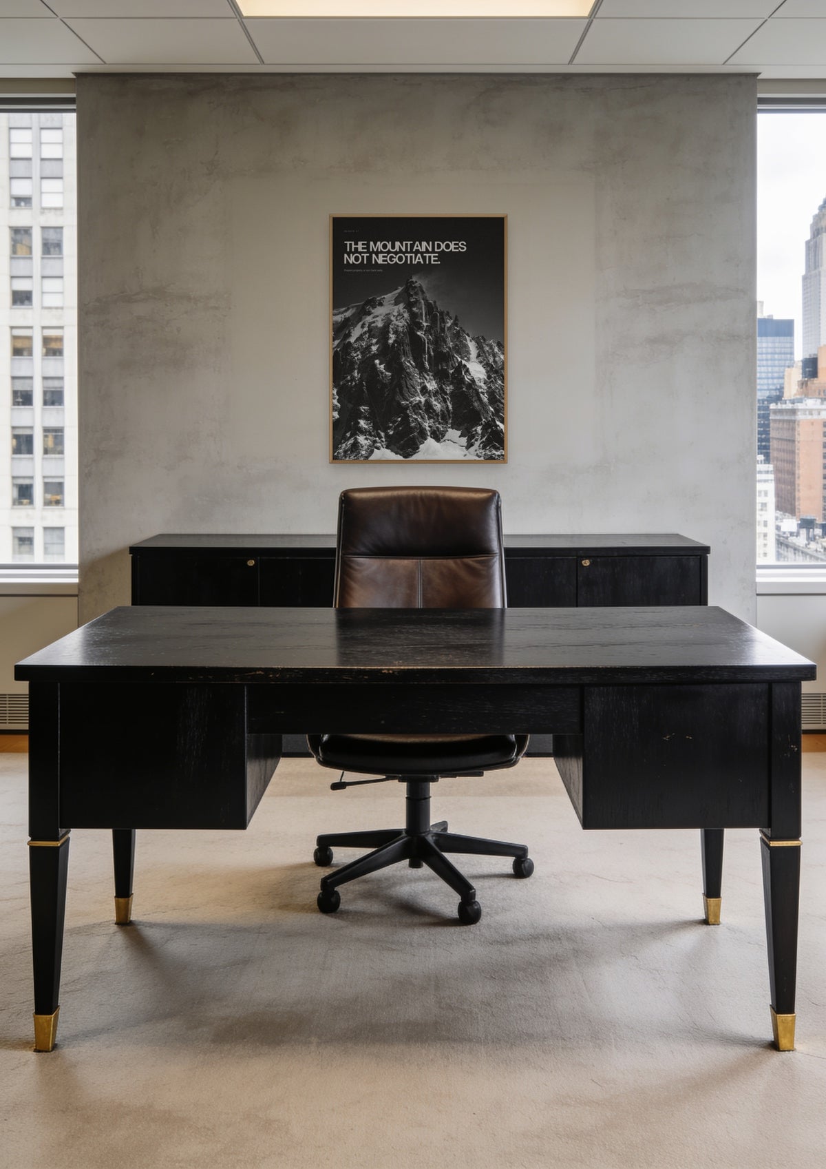 The Mountain Does Not Negotiate in a natural wood frame, shown in a Midtown Manhattan office